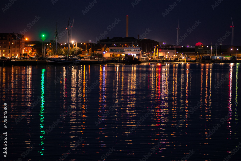 Landskrona, Sweden - August 23 2021: Night coming into Landskrona harbour with Ventrafiken - the ferries between Landskrona and the small island of Ven. Colourful lights in the industrial harbour Landskrona, Sweden - August 23 2021: Night coming into Landskrona harbour with Ventrafiken - the ferries between Landskrona and the small island of Ven. Colourful lights in the industrial harbour