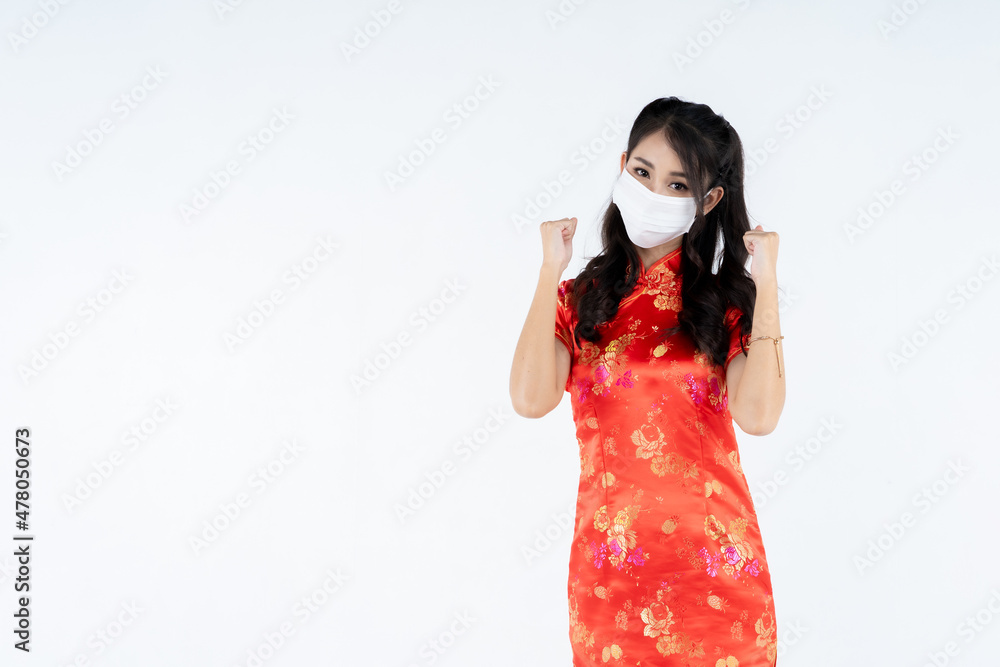 Obraz premium beauty woman wear cheongsam wearing medical mask in chinese new year