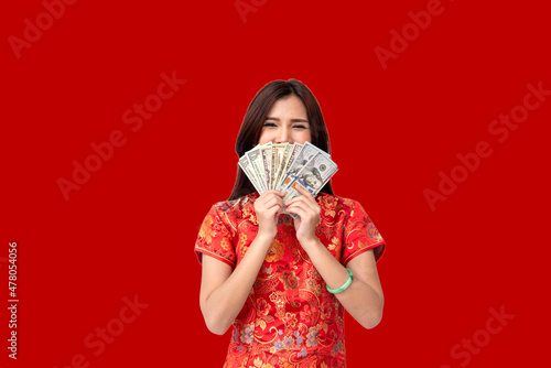 Asian chinese woman red cheongsam dress holding Money Red envelope Happy Lunar Chinese New year festival. Woman red cheongsam dress wish luck wealth happiness. China girl smiling face look at camera photo