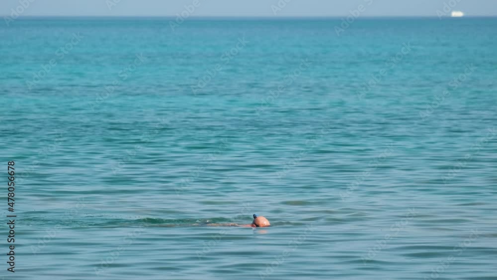 Unrecognizable man swimming with snorkeling breathing mask under sea water surface Unrecognizable man swimming with snorkeling breathing mask under sea water surface
