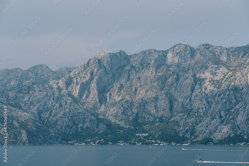 Boats sail on the Bay of Kotor against the backdrop of a mountain range