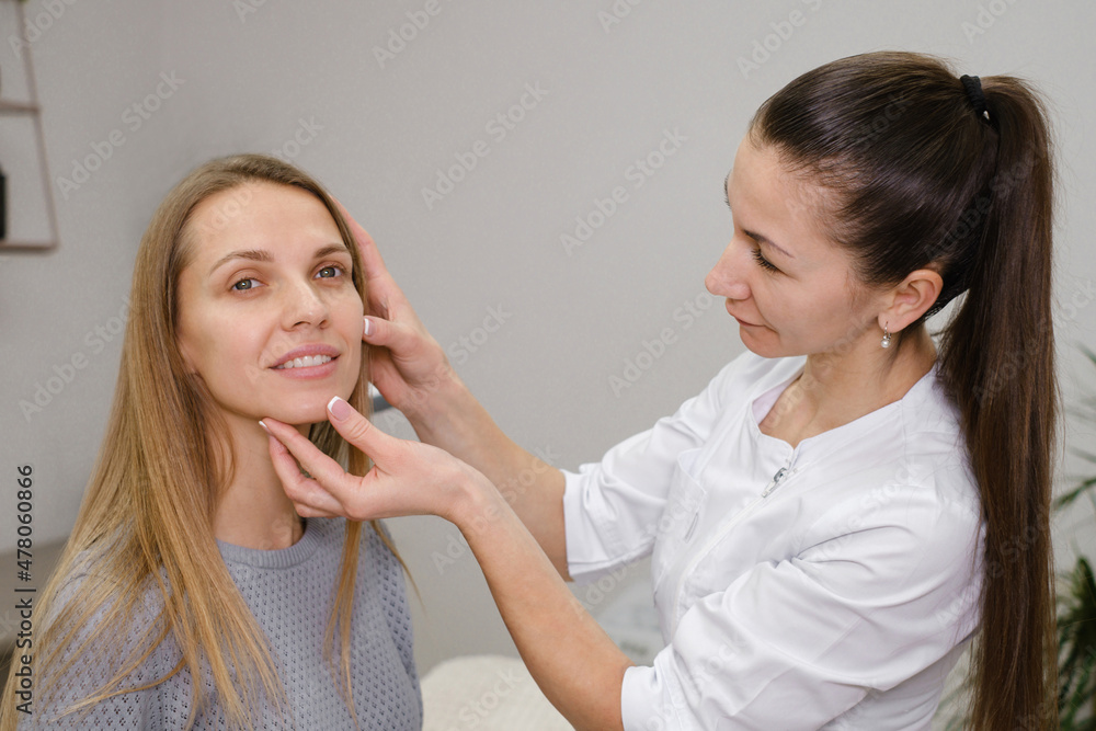 Client meeting dermatology cosmetician specialist in the room, discussion skin face problems and therapy methods. Woman showing zones for treatment. beautician with customer before procedure Client meeting dermatology cosmetician specialist in the room, discussion skin face problems and therapy methods. Woman showing zones for treatment. beautician with customer before procedure