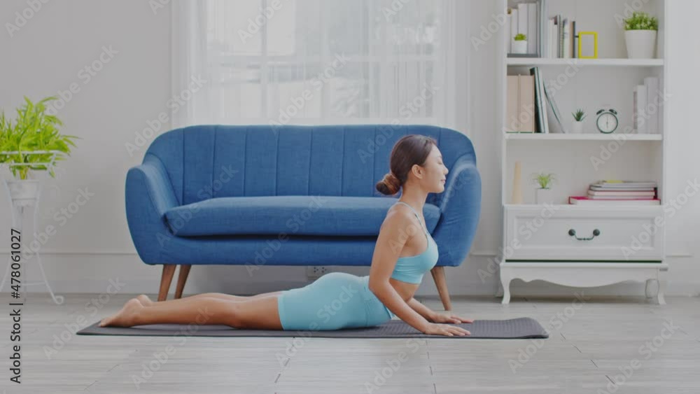 Wellness Attractive Asian woman in blue wear doing yoga Cobra pose at home to meditation comfortable and relax,Calm of healthy young woman deep breath and meditation with yoga at home,Yoga Concept Wellness Attractive Asian woman in blue wear doing yoga Cobra pose at home to meditation comfortable and relax,Calm of healthy young woman deep breath and meditation with yoga at home,Yoga Concept