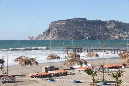 Beach umbrellas against the backdrop of a stormy sea and a historic mountain, Alanya, December 2021