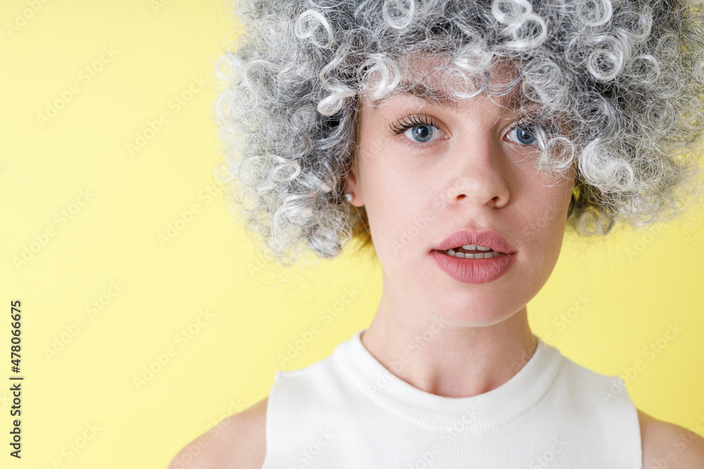Attractive young woman in wig standing in studio