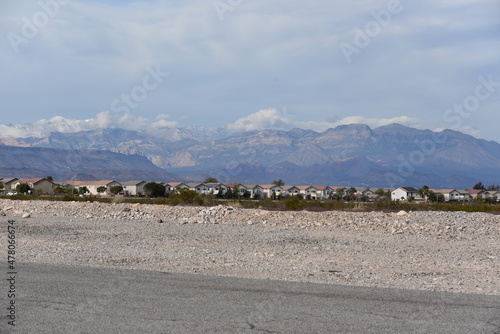 A view of residential district from the road with mountain in the back and a cloudy sky daytime view of homes