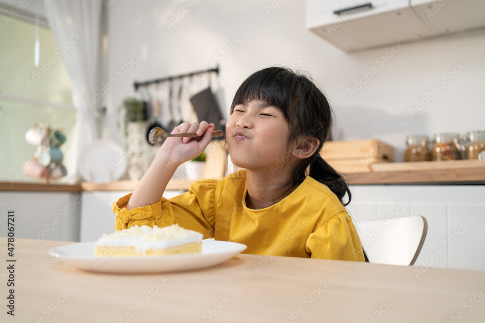 Portrait of Asian happy young kid girl eating cake in kitchen at home. Portrait of Asian happy young kid girl eating cake in kitchen at home.