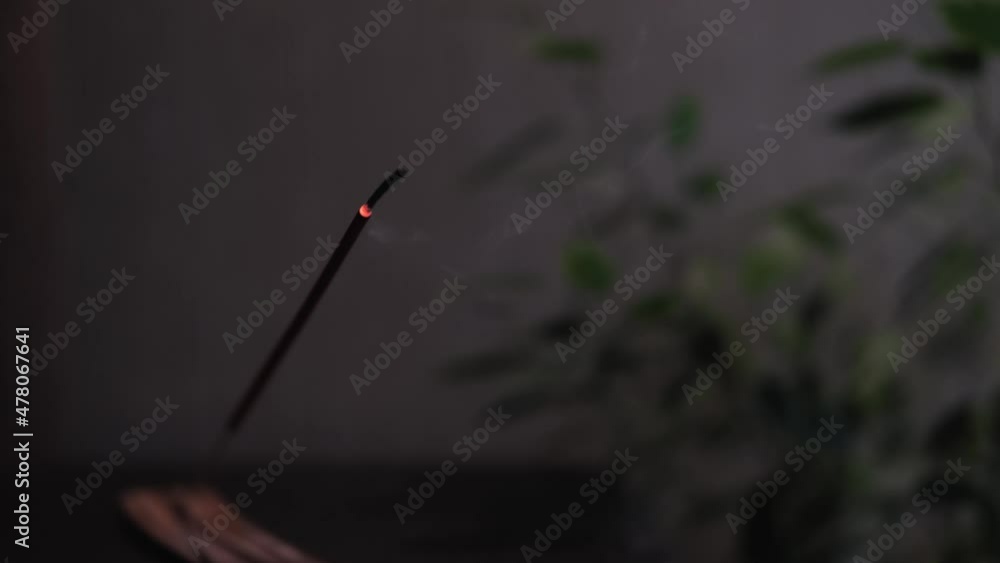 Meditation concept. Close-up of steaming incense stick in dusk of room. Slow motion Meditation concept. Close-up of steaming incense stick in dusk of room. Slow motion