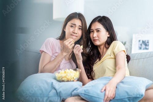 Asian young woman couple watch jump scare movie on television at home.