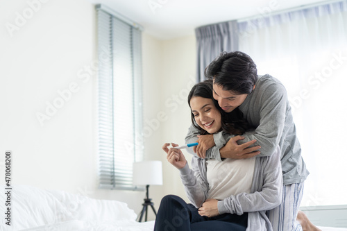 Asian young couple feeling happy after look at positive pregnancy test