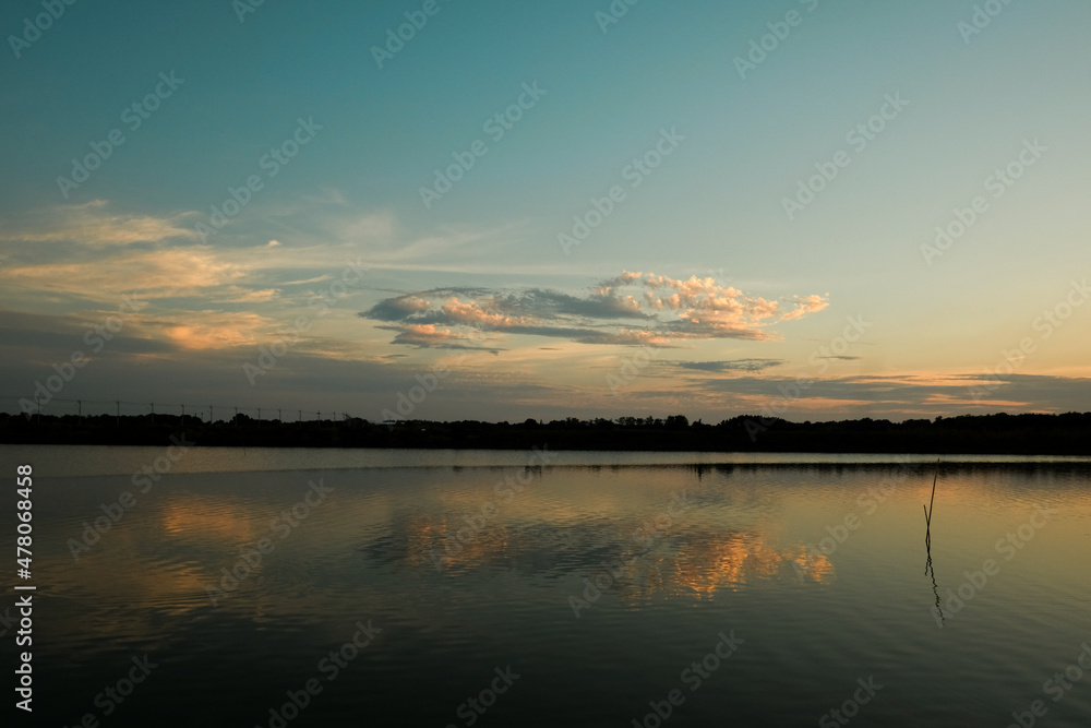 Beautiful sunset on the river bank,  blue sky and yellow sunlight. landscape during sunset