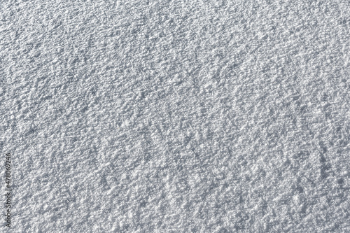 The pattern and texture of a smooth snow surface. The natural color of the snow as a background.