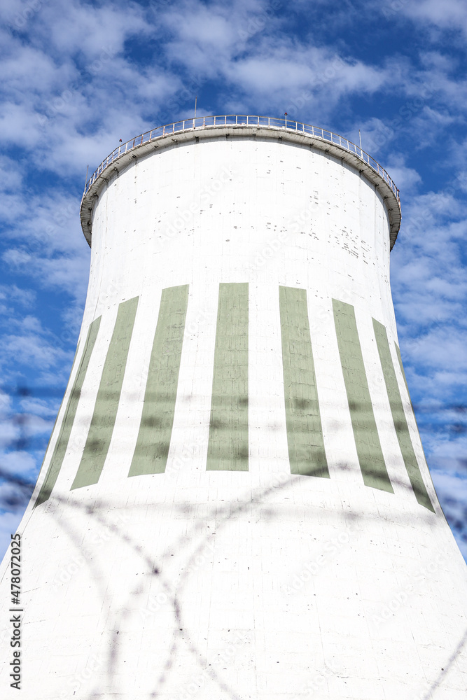 Large power plant white chimney with unsharp barbed wires in foreground. Large power plant white chimney with unsharp barbed wires in foreground.