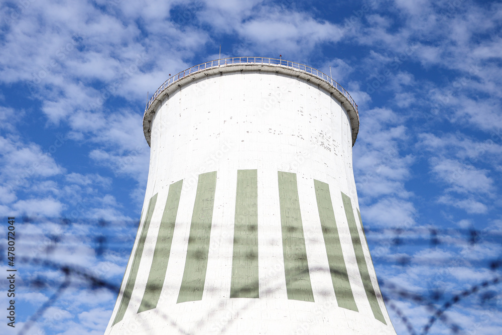 Large power plant white chimney with unsharp barbed wires in foreground. Large power plant white chimney with unsharp barbed wires in foreground.