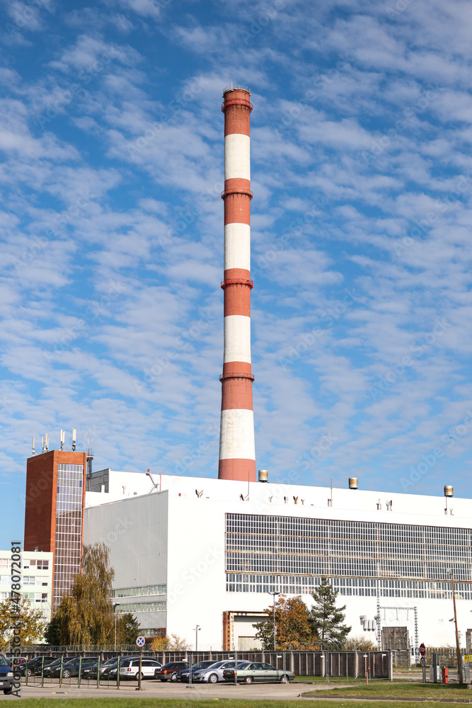 Large, tall electricity thermal power plant red, white color chimney building factory. Large, tall electricity thermal power plant red, white color chimney building factory.