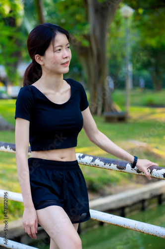 Asian woman wearing a black dress portrait in the park 