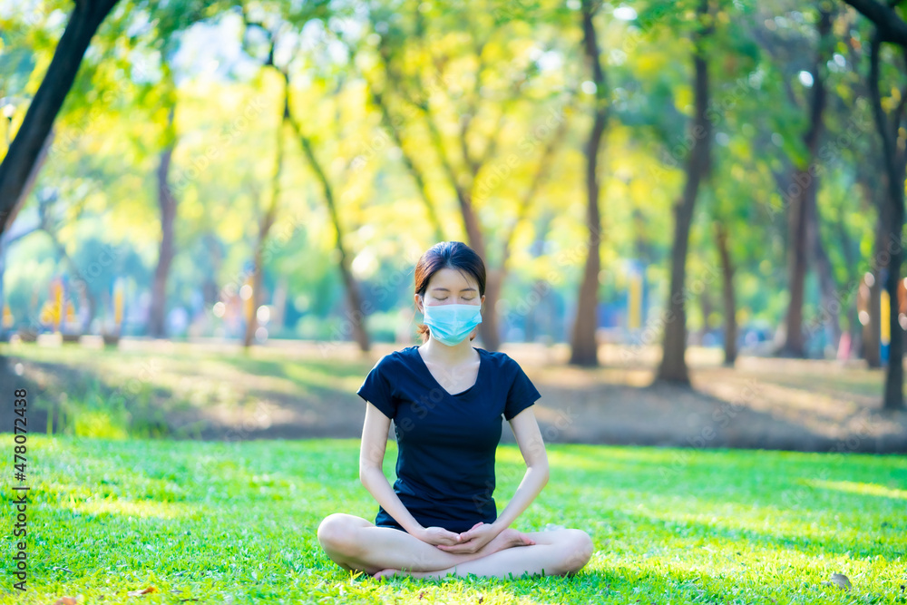 Asian woman wearing a black dress with medical mask Meditation in the park