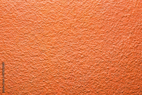 Red orange wall background. Vibrant color cement texture. Plaster wall pattern. Color wrinkled backdrop for graphic design.