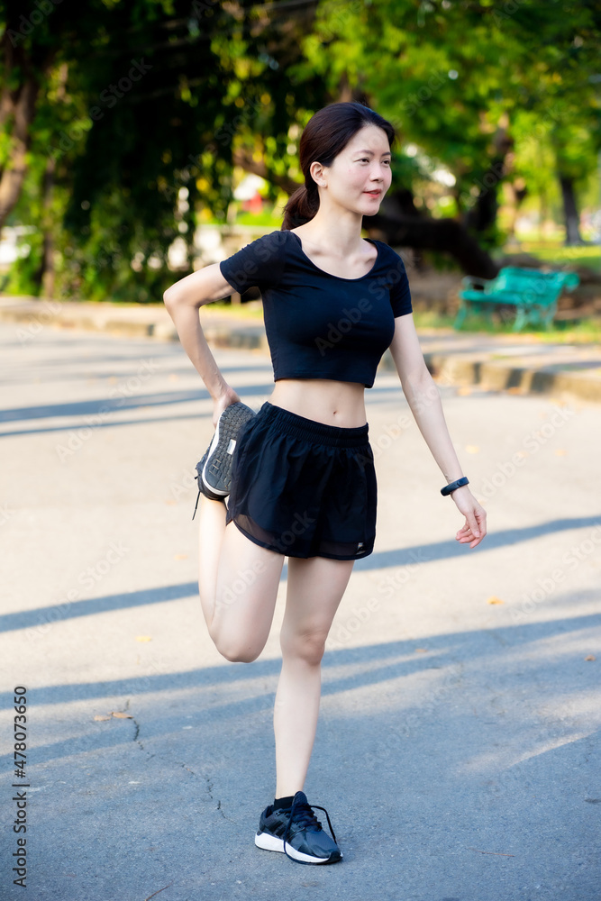 Asian woman wearing a black dress warm-up before Jogging in the park Asian woman wearing a black dress warm-up before Jogging in the park