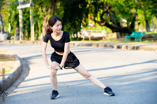 Asian woman wearing a black dress warm-up before Jogging in the park