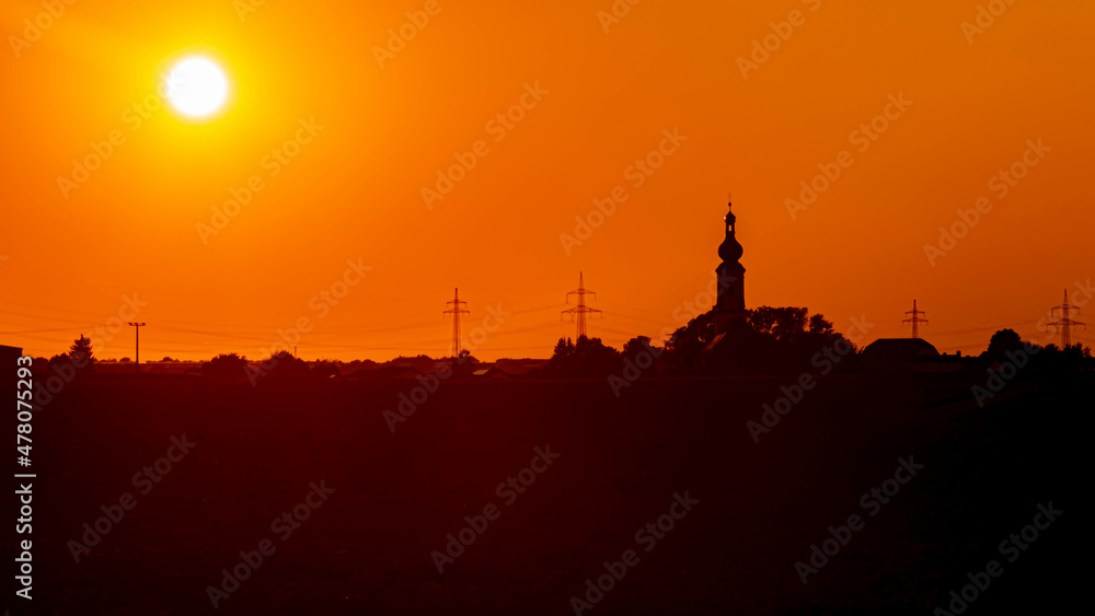 Beautiful sunset view with the silhouette of a church near Loh, Bavaria, Germany