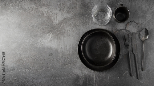 Table setting en black colour plate, cup and cutlery . Large image for banner.