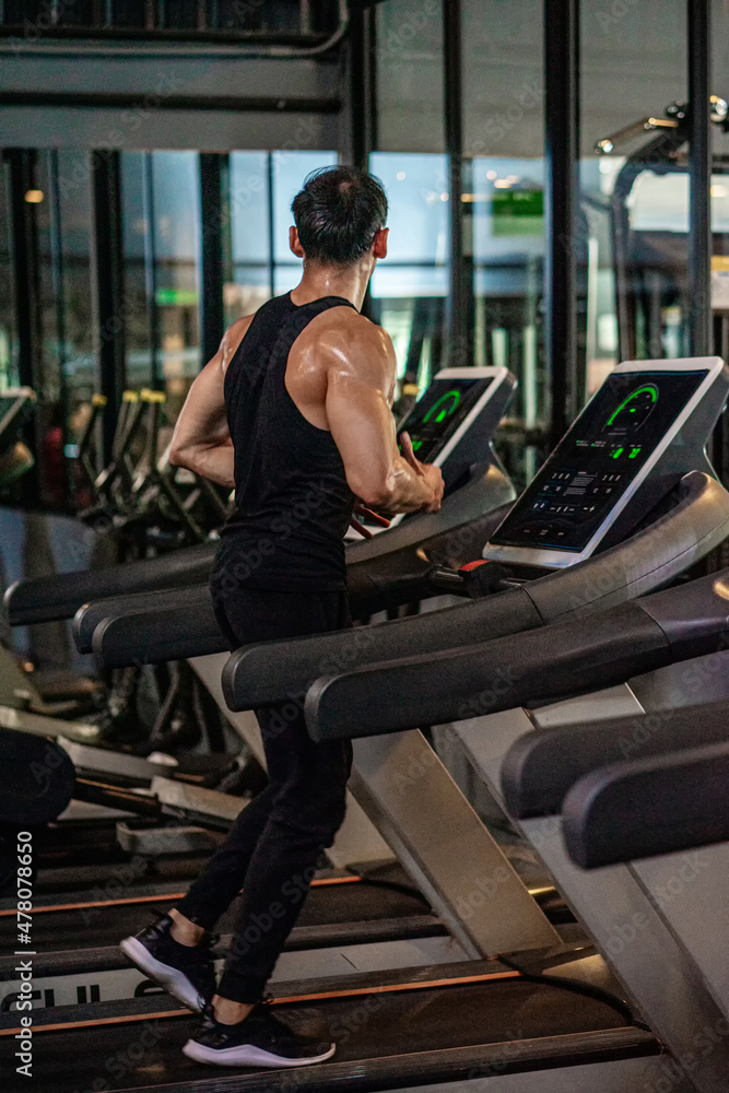 Asian men wear black workout in fitness center Asian men wear black workout in fitness center