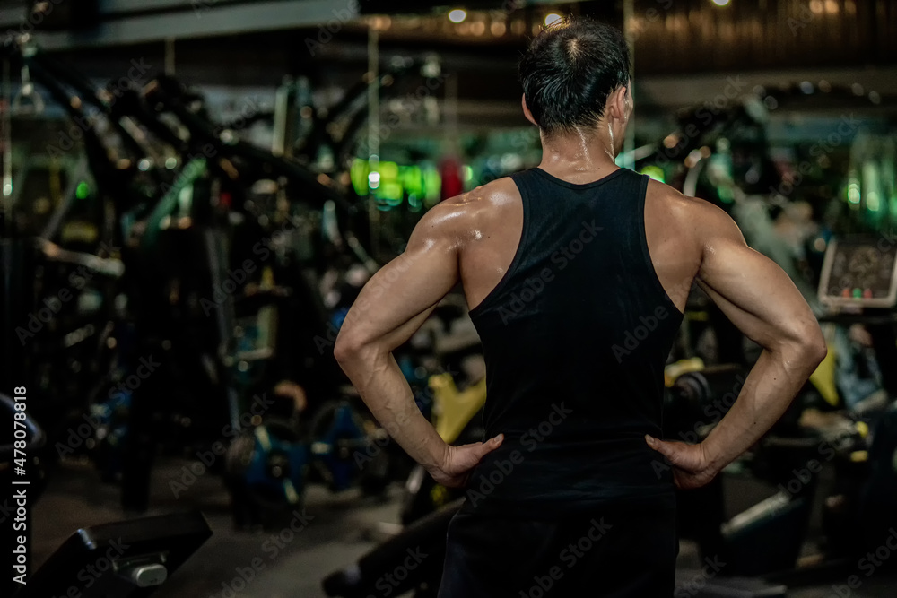 Asian men wear black workout in fitness center Asian men wear black workout in fitness center