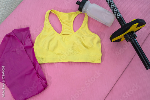 brand dumbbells kettlebell ball with sand water gums randomly arranged on pink and cherry mats photo