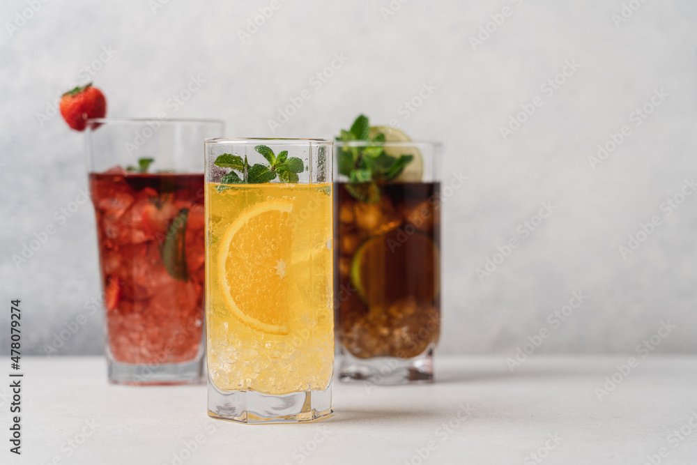 Set of various summer refreshing lemonades. Strawberry, orange, cuba libre drinks with ice on light background Set of various summer refreshing lemonades. Strawberry, orange, cuba libre drinks with ice on light background