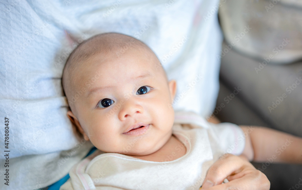 Adorable newborn baby with smiling happy face in mother's embrace. Little innocent new infant child in first day of life. Mother day concept. Adorable newborn baby with smiling happy face in mother's embrace. Little innocent new infant child in first day of life. Mother day concept.
