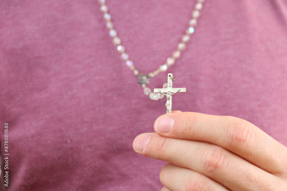 Person showing catholic rosary cross Person showing catholic rosary cross