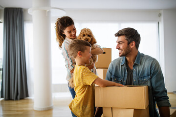 Happy family unpacking boxes in new home on moving day