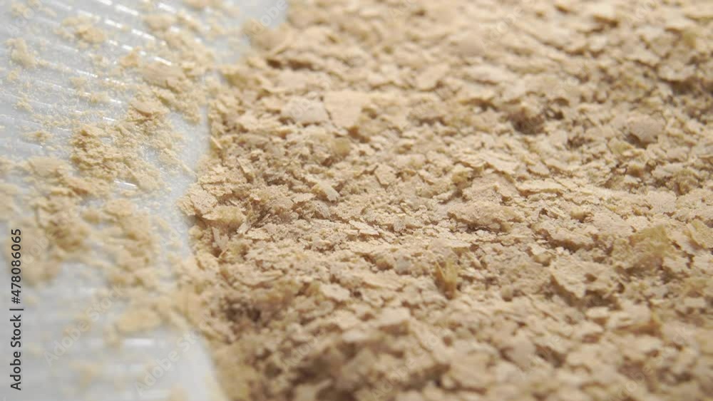 Dry beer yeast supplement in white plate. Vegetarian superfood. Healthy diet product. Macro. Rotation Dry beer yeast supplement in white plate. Vegetarian superfood. Healthy diet product. Macro. Rotation