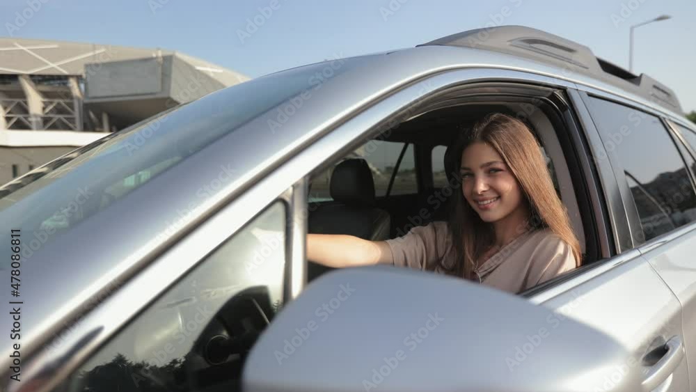 The young woman is looking at the camera and smiling. She is looking out the open window. The wind is blowing her hair. The camera is moving around. 4K The young woman is looking at the camera and smiling. She is looking out the open window. The wind is blowing her hair. The camera is moving around. 4K