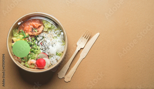Photography Healthy salad lunch with salmon in craft-paper recycled bowl packages with wooden cutlery