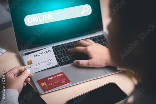 Model credit card and using laptop. woman hold visa card and working from home. Online shopping, e-commerce, internet banking, spending money, work from home concept. Internet online banking