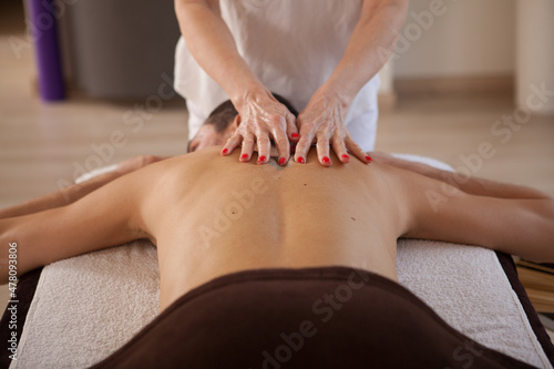 Male client getting professional back massage at spa center