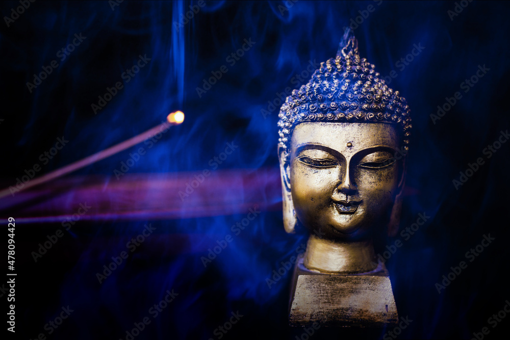 buddha next to incense smoke