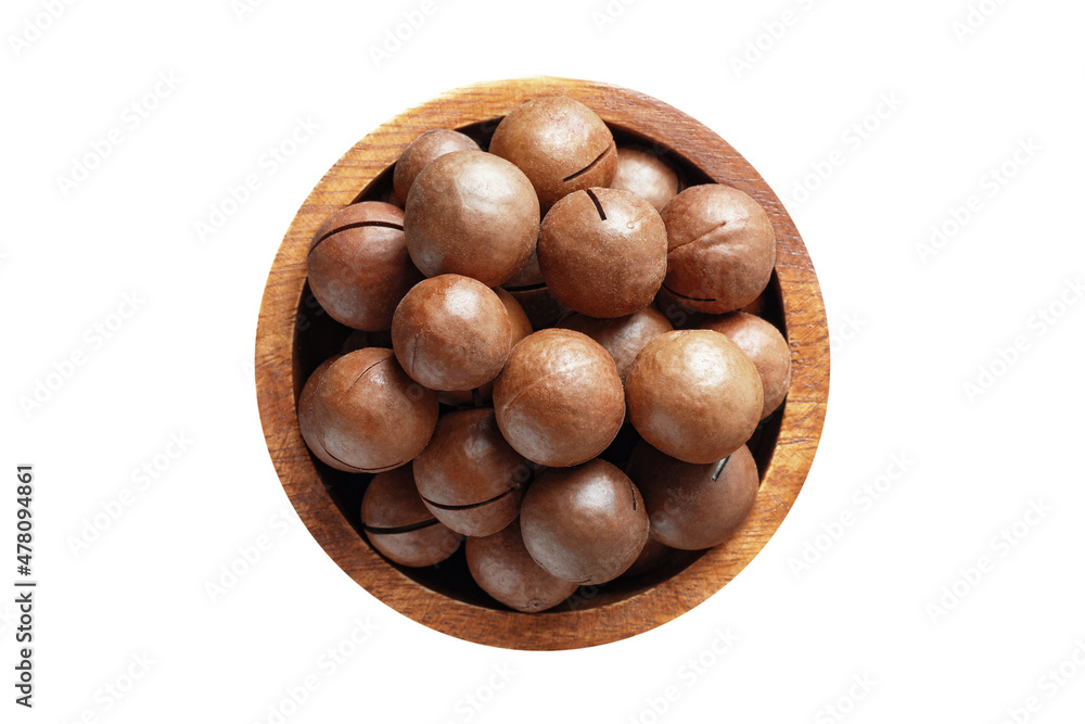 shelled macadamia nuts in wooden bowl isolated on white background. Vegan food, top view. shelled macadamia nuts in wooden bowl isolated on white background. Vegan food, top view.