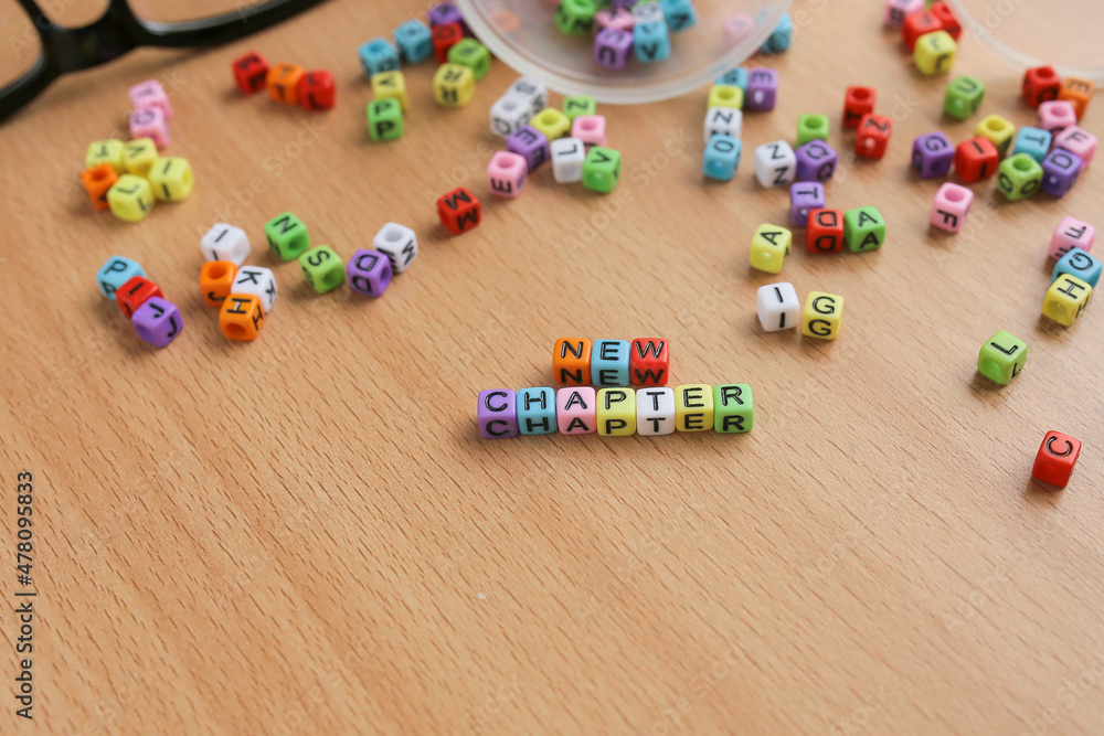NEW CHAPTER letterings on colorful cubes. New chapter in life concept NEW CHAPTER letterings on colorful cubes. New chapter in life concept