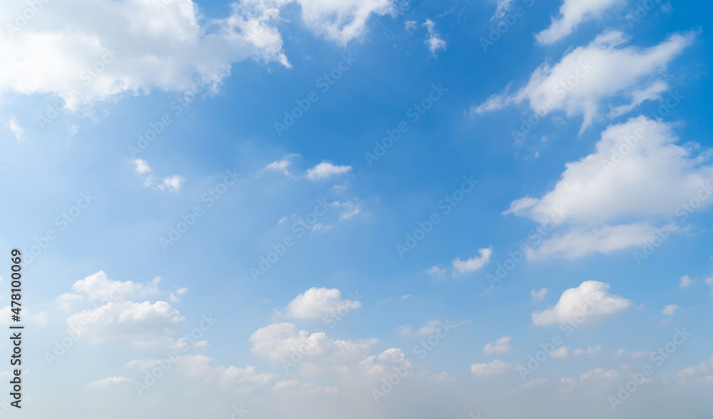 Clear blue sky with white fluffy clouds at noon. Day time. Abstract nature landscape background.