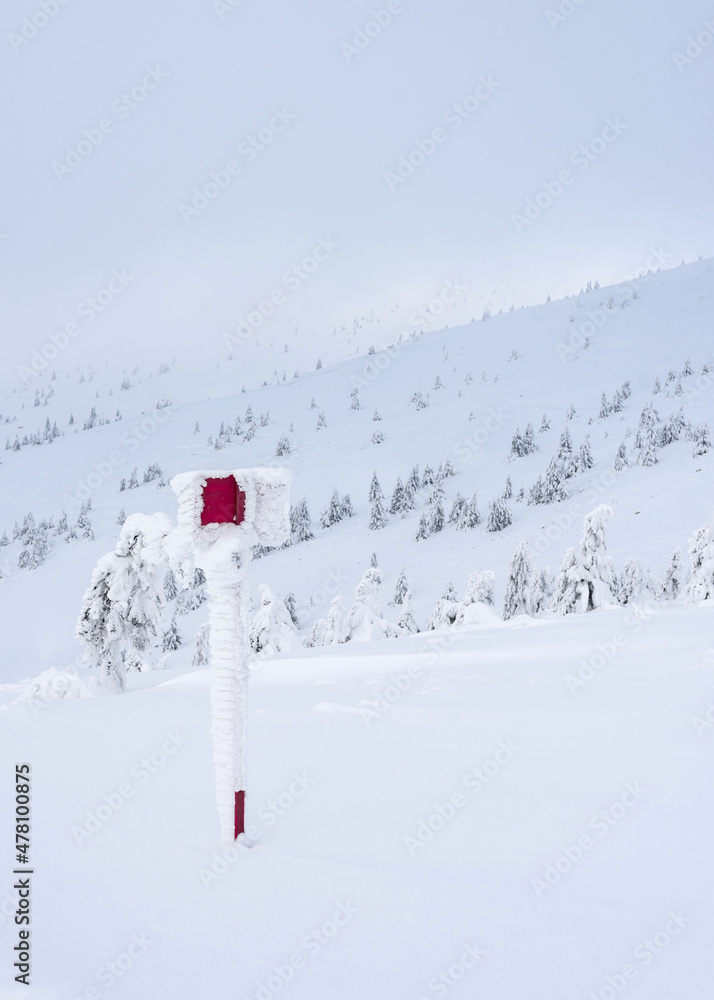 Snow covered red sign on the mountainside. Winter mountain landscape. Snow covered red sign on the mountainside. Winter mountain landscape.