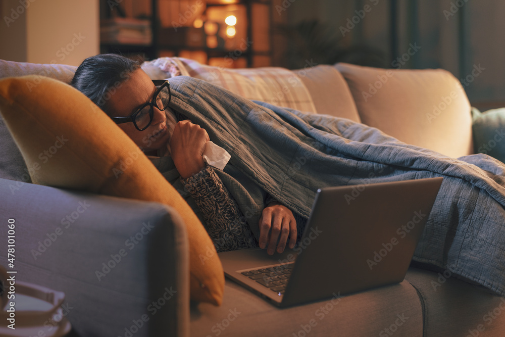 Sick woman with flu connecting with her laptop - obrazy, fototapety, plakaty 