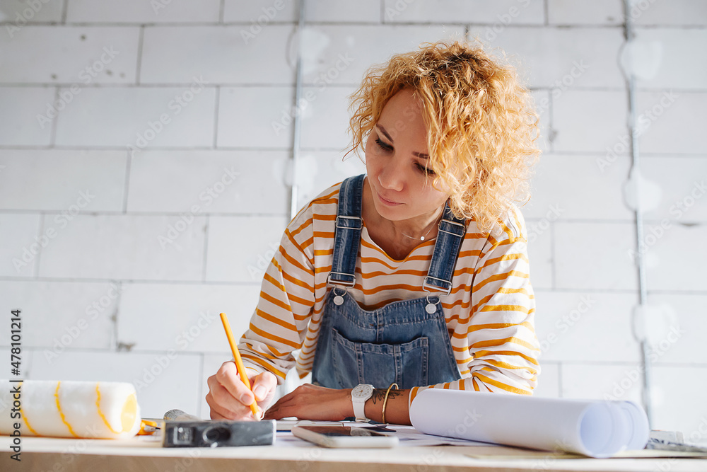 Low angle image of a female construction engineer working on a blueprint. Low angle image of a female construction engineer working on a blueprint.