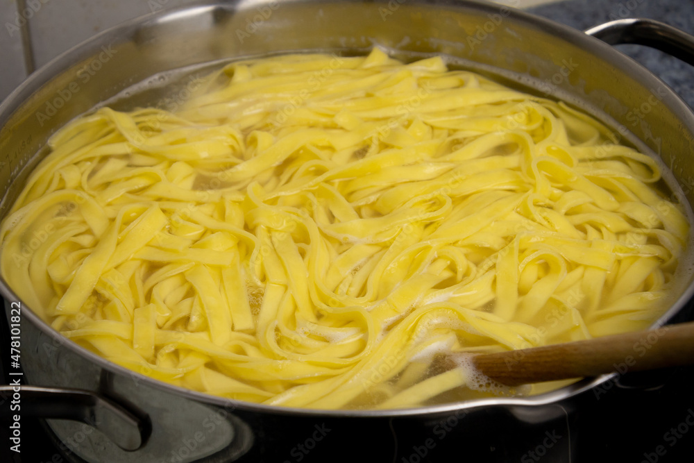 cooking pasta in a pot of boiling water cooking pasta in a pot of boiling water