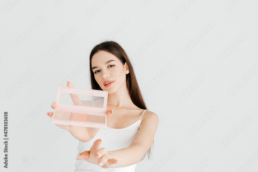 Portrait of beautiful girl showing a contouring palette with bronzer, highlighter and a blush, to the camera. The work of make up artist Portrait of beautiful girl showing a contouring palette with bronzer, highlighter and a blush, to the camera. The work of make up artist