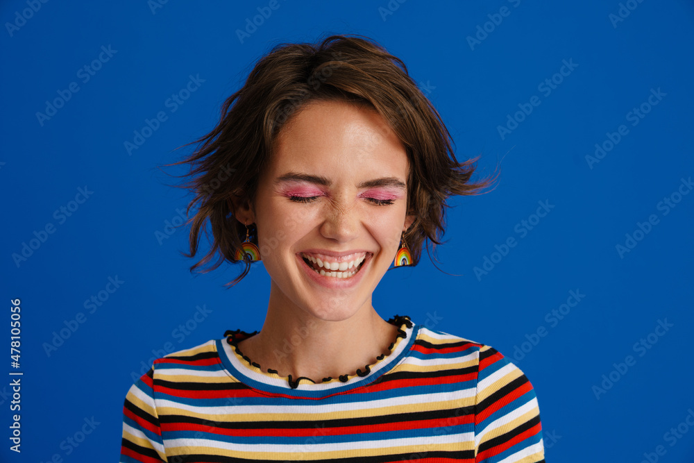 White woman in rainbow earrings laughing while posing on camera White woman in rainbow earrings laughing while posing on camera