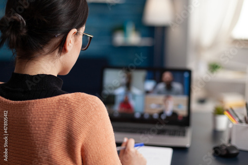 Photos Student in group videocall taking notes