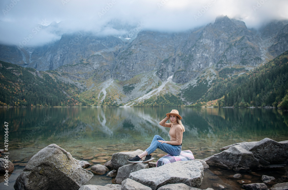 Young woman on a hiking trip sitting on a rock Young woman on a hiking trip sitting on a rock